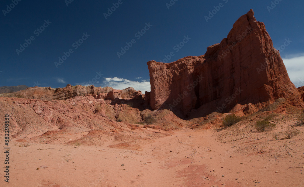 The arid desert. View of the red sand, sandstone and rocky formations under a blue sky. 