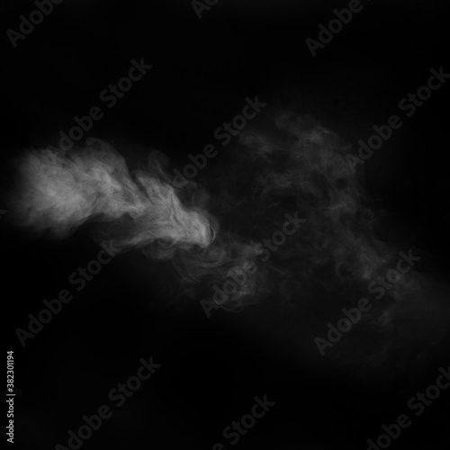 White vapour spray steam from air saturator. Smoke fragments on a black background. Abstract background