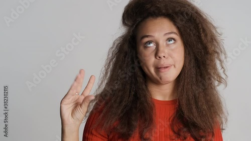 Bored brunette girl showing bla bla gesture has not interested conversation isolated on white background