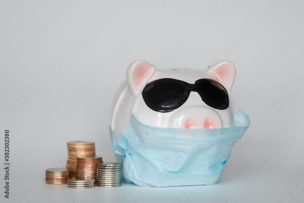 the collapse of financial markets and the danger to financial savings due to a pandemic virus.masked piggy bank the collapse of financial markets and the danger to financial savings due to a pandemic virus.masked piggy bank