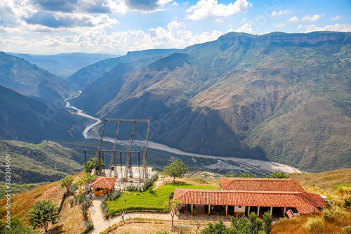 Panoramic view of mountains , Chicamocha canyon and buildings with white clouds from Monument of the Virgin Mary at Chicamocha National Park, Colombia
 photo