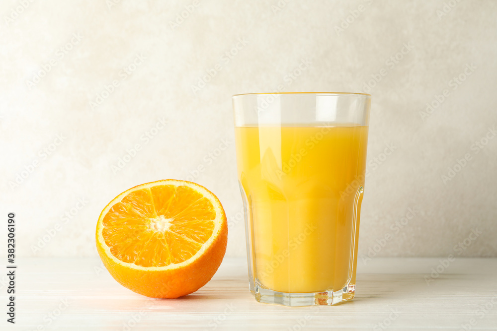 Glass of fresh orange juice on white wooden table