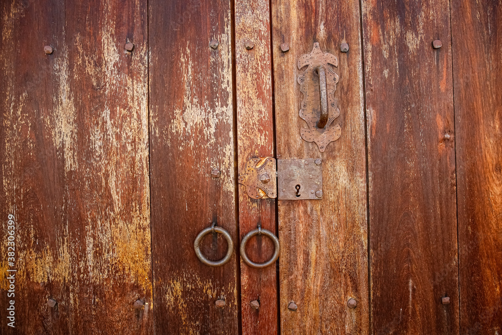 Close up view to a wooden weathered door with door rings in historic town Barichara, Colombia
Close up view to a wooden weathered door with door rings in historic town Barichara, Colombia