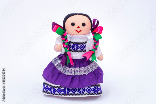 Muñeca de trapo tradicional con vestido morado y trenzas