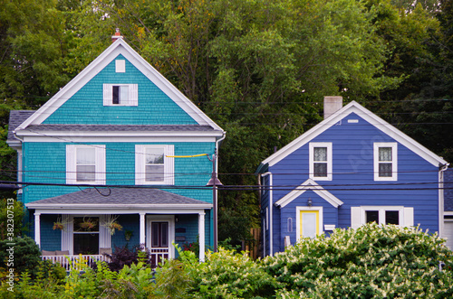 Photography Picturesque city scape with historic New England style houses or cottages, flowe