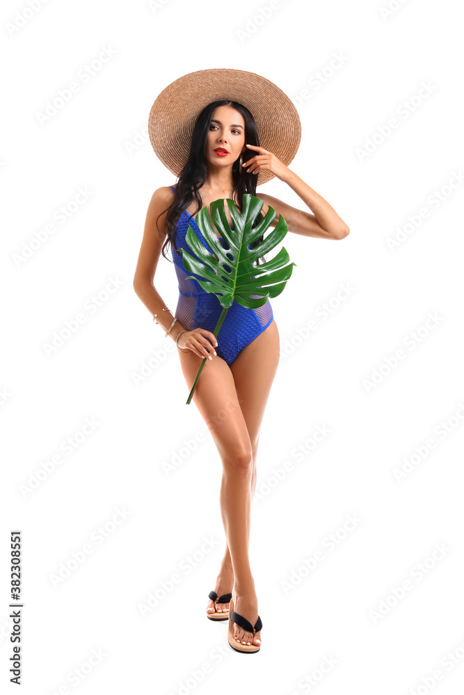 Beautiful young woman in swimming suit and with tropical leaf on white background Beautiful young woman in swimming suit and with tropical leaf on white background