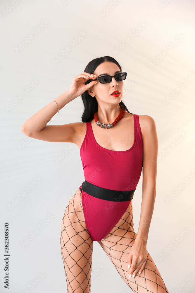 Obraz premium Stylish young woman in swimming suit on grey background
