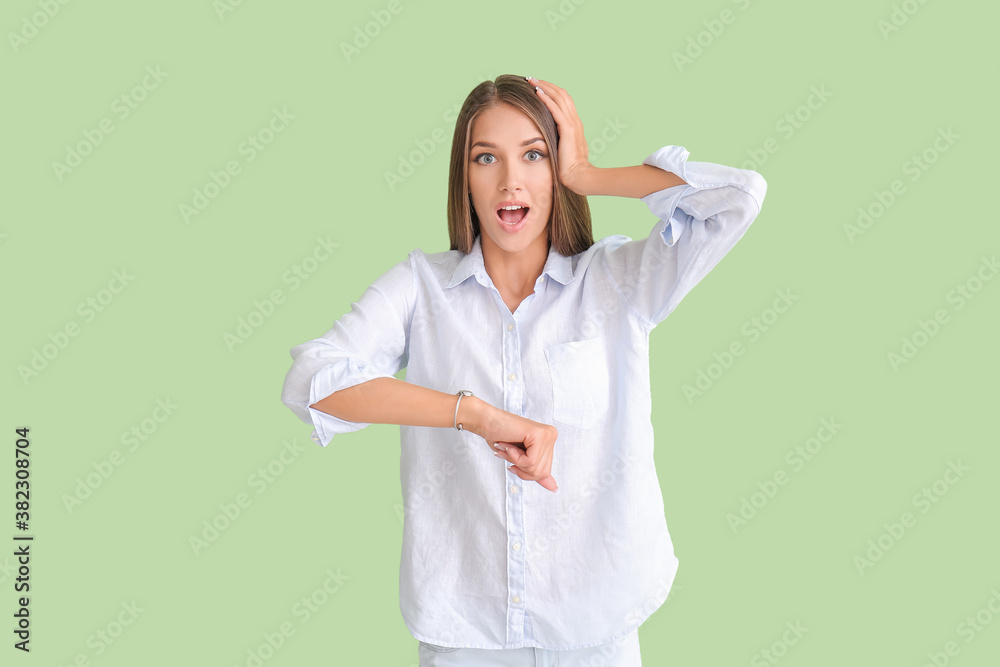 Shocked young woman with wristwatch on color background Shocked young woman with wristwatch on color background