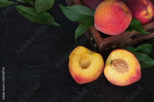 ripe peaches on the table close-up. peach halves on a wooden background close-up. peaches and peach tree leaves on the table.