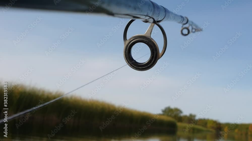 fishing line passes through the rings on a spinning rod, trolling fishing from a boat, close-up, first-person view fishing line passes through the rings on a spinning rod, trolling fishing from a boat, close-up, first-person view