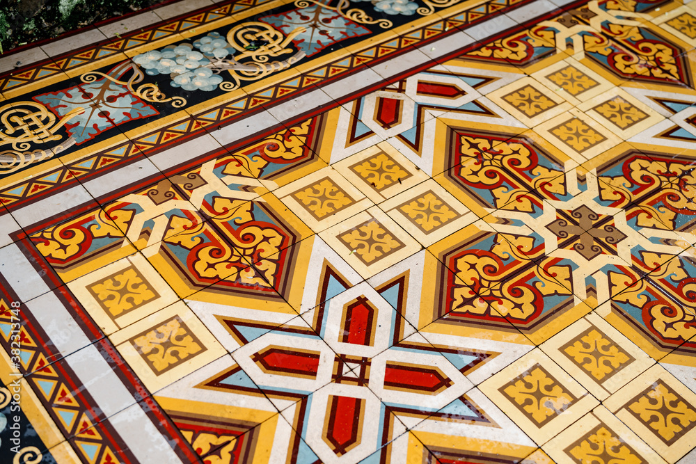 Floor tiles with arabesque ornaments in yellow, white and red colors.