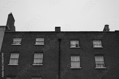 Photography Black and white old building in the city with multiple windows