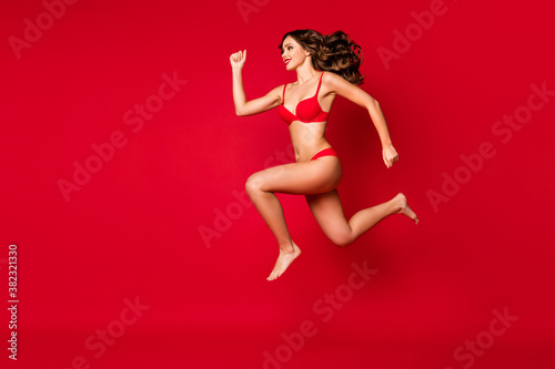 Full length body size view of nice attractive gorgeous slim fit sporty bare foot purposeful cheerful wavy-haired girl jumping running fast isolated on bright vivid shine vibrant red color background