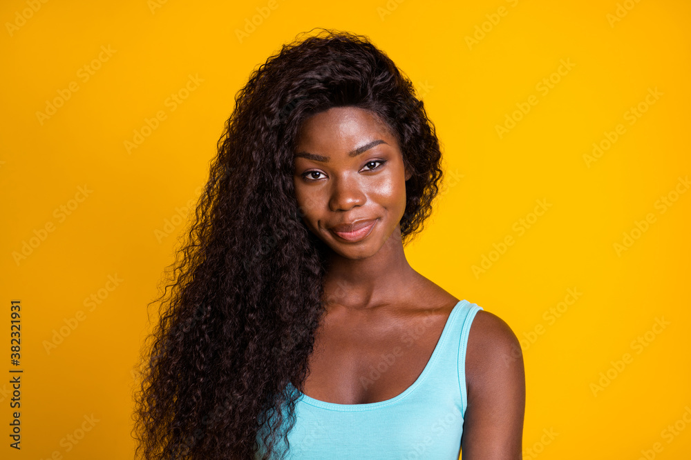 Photo portrait of smug african american woman smirking wearing blue tank-top isolated on bright yellow colored background Photo portrait of smug african american woman smirking wearing blue tank-top isolated on bright yellow colored background
