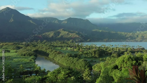 Hanalei Bay Kauai Hawaii perfect reveal shot. Overview nature surrounding mountains and ocean on beautiful sunny morning photo