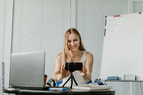 Side hustle, earn extra, money making, side job, side money, second job, hustling, hustle gig, gig economy concept. Young woman speaking in front of camera for vlog blog, recording video tutorial
