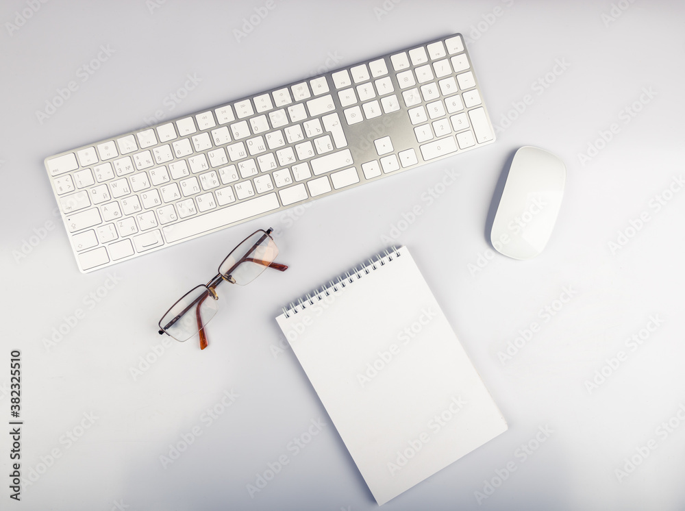 white office desk table with computer keyboard, glasses and mouse. white office desk table with computer keyboard, glasses and mouse.