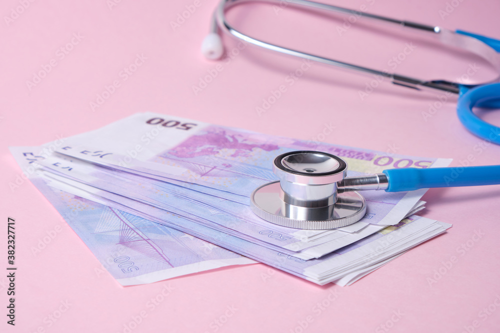 stethoscope and euro banknotes on pink background, concept of the impact of the crisis on the exchange rate stethoscope and euro banknotes on pink background, concept of the impact of the crisis on the exchange rate
