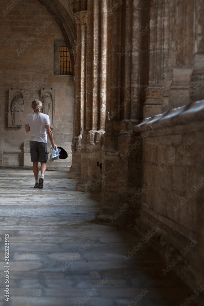 Turista cruzando un pasillo de la Catedral de Oviedo 