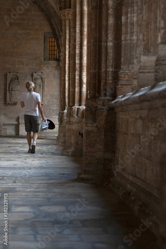 Turista cruzando un pasillo de la Catedral de Oviedo 