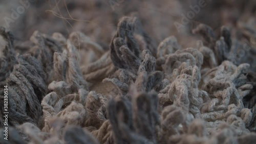 Extreme close up shaggy mop and trash on it. Texture, background. Macro shot with slide or move camera.
