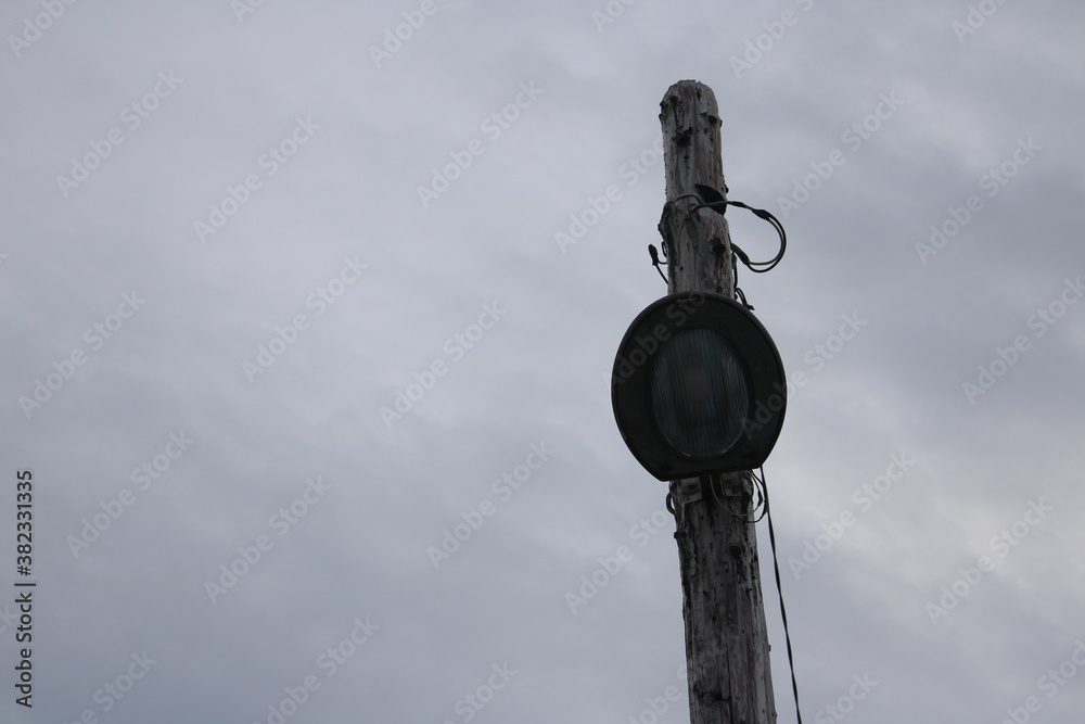 Fototapeta premium Old wooden utility pole and dark sky