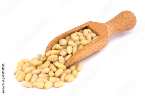wooden scoop with pine nuts isolated on white