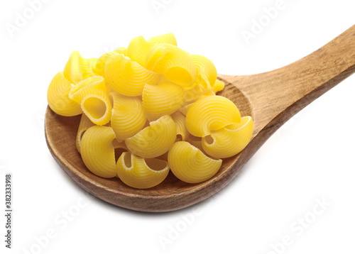 Pasta lumaconi rigati pile in wooden spoon isolated on white background