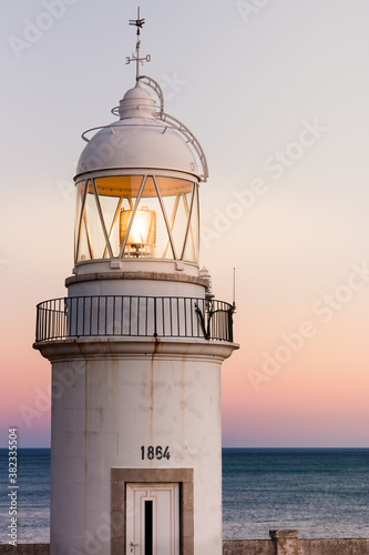 old lighthouse on the coast with a beautiful sunset in the background