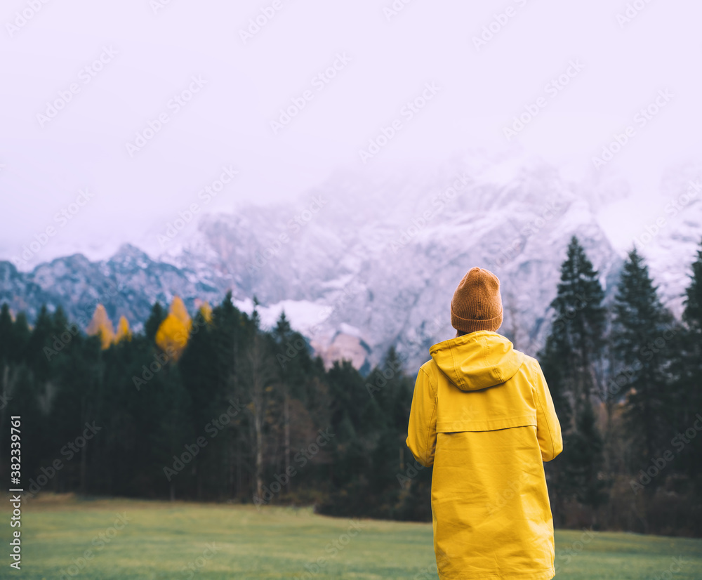 Woman in yellow jacket on nature background of mountains.