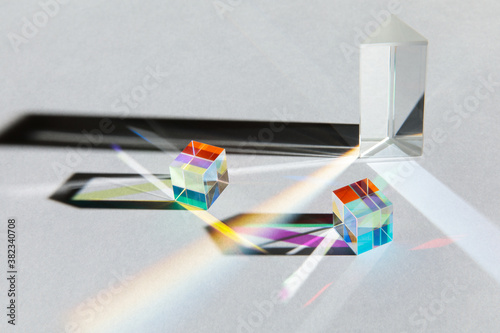 Glass geometric figures prisms with light diffraction of spectrum colors and complex reflection with trendy light and hard shadows on a white background photo