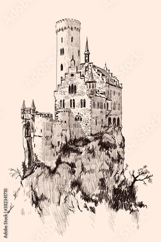 Medieval stone castle with towers on a high mountain cliff.