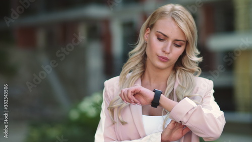 Closeup business woman looking at smart watch. Woman looking at watch outdoor