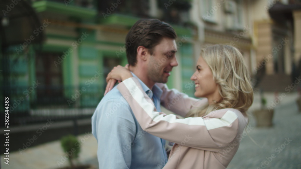 Business couple looking at each other outside. Love couple hugging at date Business couple looking at each other outside. Love couple hugging at date