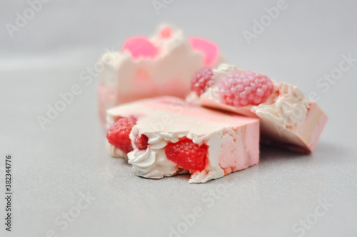Handmade pink soap.Cold Processed Handcrafted Soap.Home made soap look like cake, ice cream with berries,glitter on gray background with sparkles.Natural homemade cosmetics and handmade soaps concept
