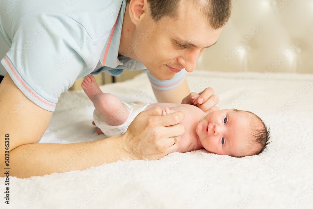 Woman and man giving a newborn baby. Mom, dad and baby. Close-up. Portrait of a young smiling family with a newborn baby in their arms. Happy family on the background. Woman and man giving a newborn baby. Mom, dad and baby. Close-up. Portrait of a young smiling family with a newborn baby in their arms. Happy family on the background.
