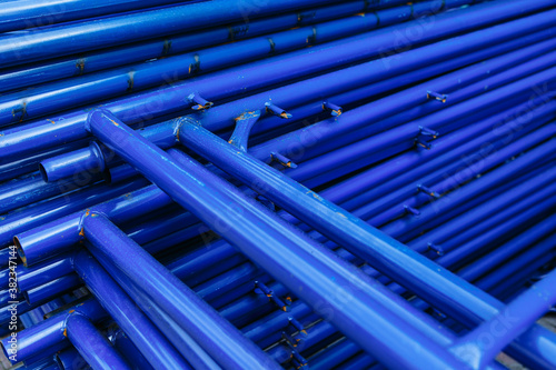 Blue pipes lying on top of each other. Scaffolding for building repairs