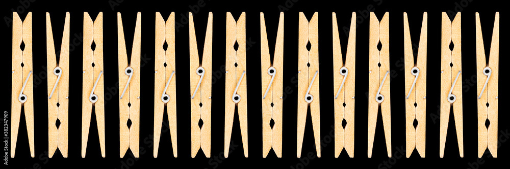 White housewife clothespins isolated on black background