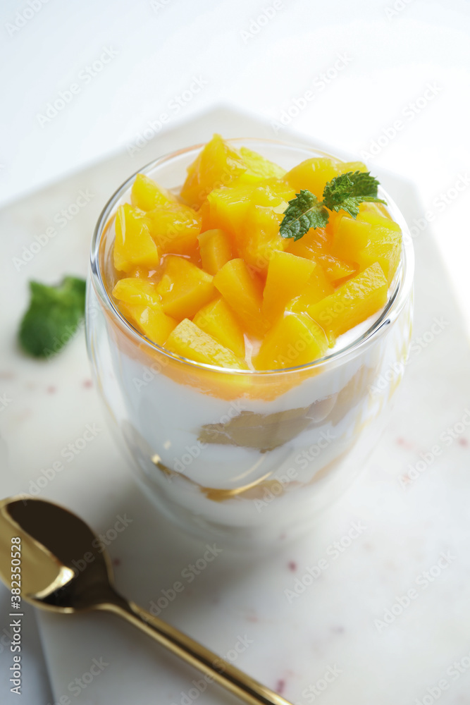 Tasty peach dessert with yogurt served on white table