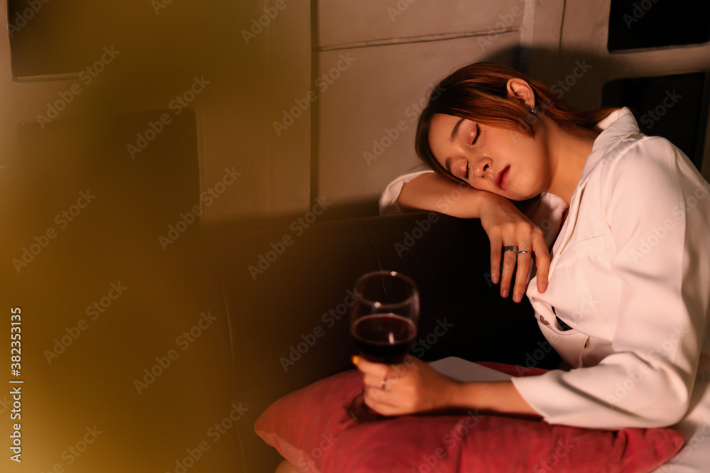 Drunk business woman sleeping on a couch after drinking red wine too much. Stock Photo Adobe Stock