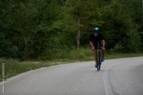 Fototapeta Naklejka Na Ścianę i Meble -  triathlon athlete riding a bike wearing black