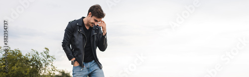 Panoramic shot of man in leather jacket standing outdoors