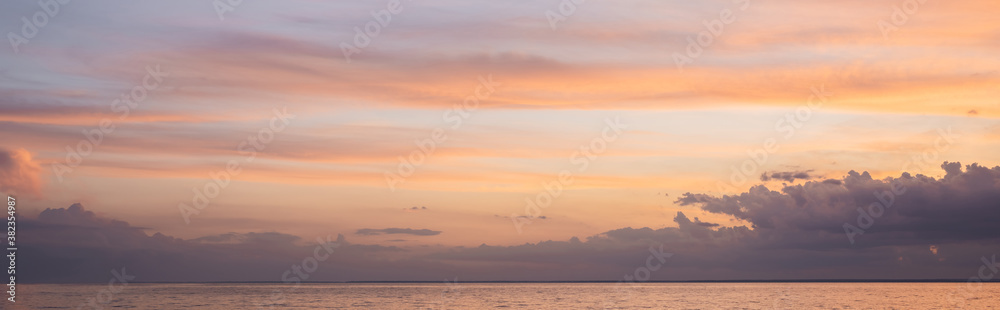Panoramic shot of sea and cloudy sky at sunset