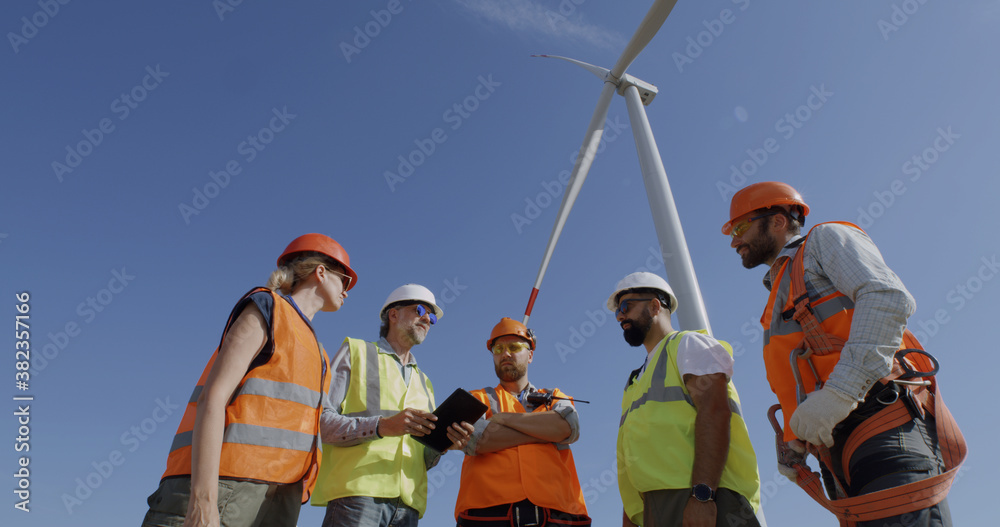 Colleagues discussing windmill on wind farm Colleagues discussing windmill on wind farm