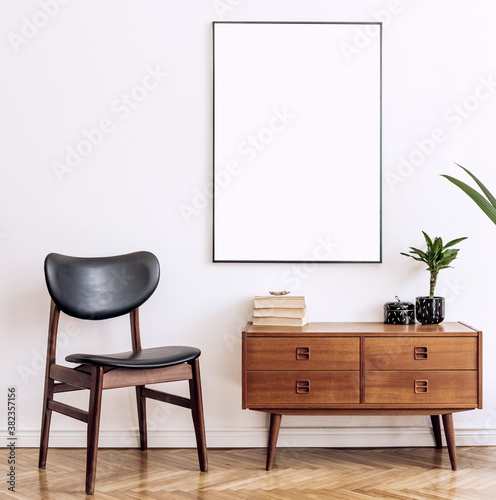 Stylish and retro living room with design vintage wooden commode, chair and elegant personal accessories. Mock up poster map on the wall. Template. Vintage home decor.
