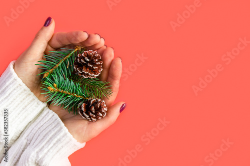 Christmas ornaments in the hands of a girl on a red background. Concept.