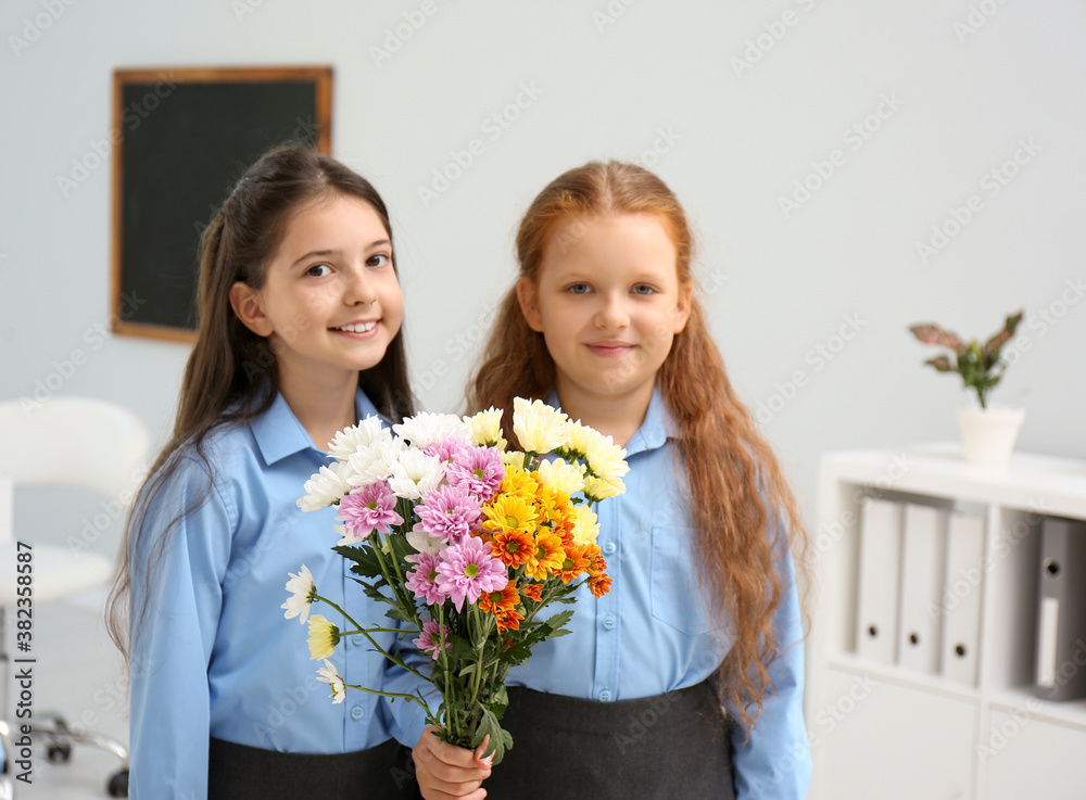 Happy schoolgirls with bouquet in classroom. Teacher's day Happy schoolgirls with bouquet in classroom. Teacher's day