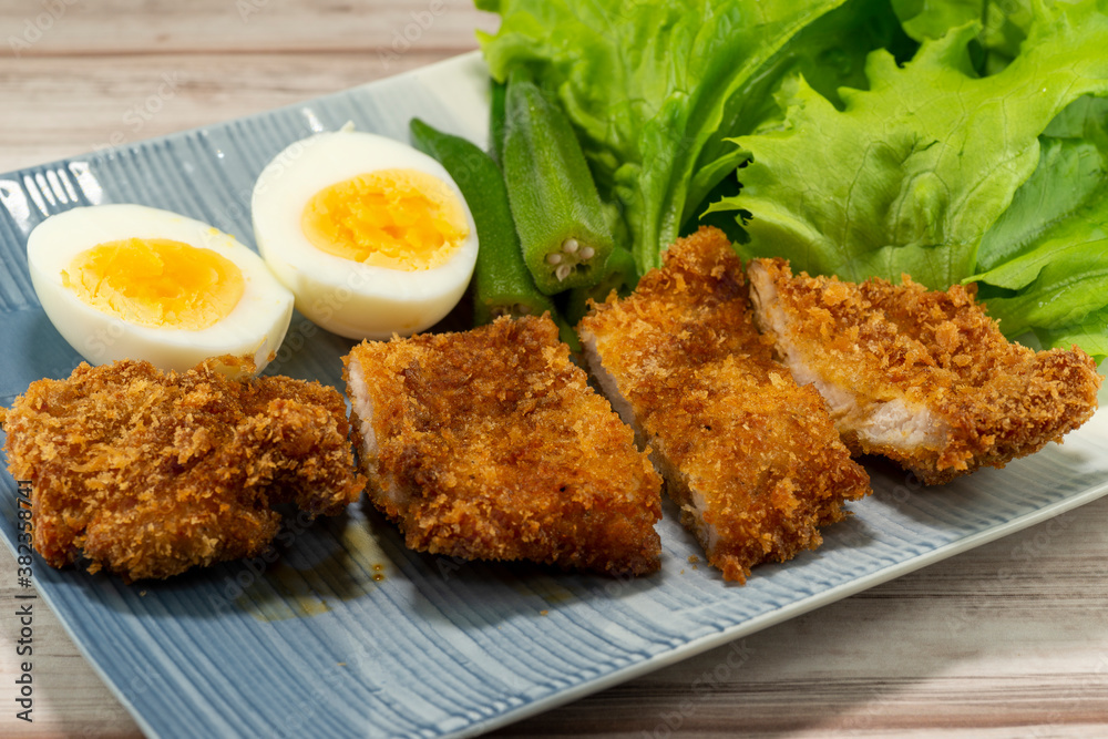 Homemade Japanese pork cutlet served with boiled egg, okra and baby leaves Homemade Japanese pork cutlet served with boiled egg, okra and baby leaves