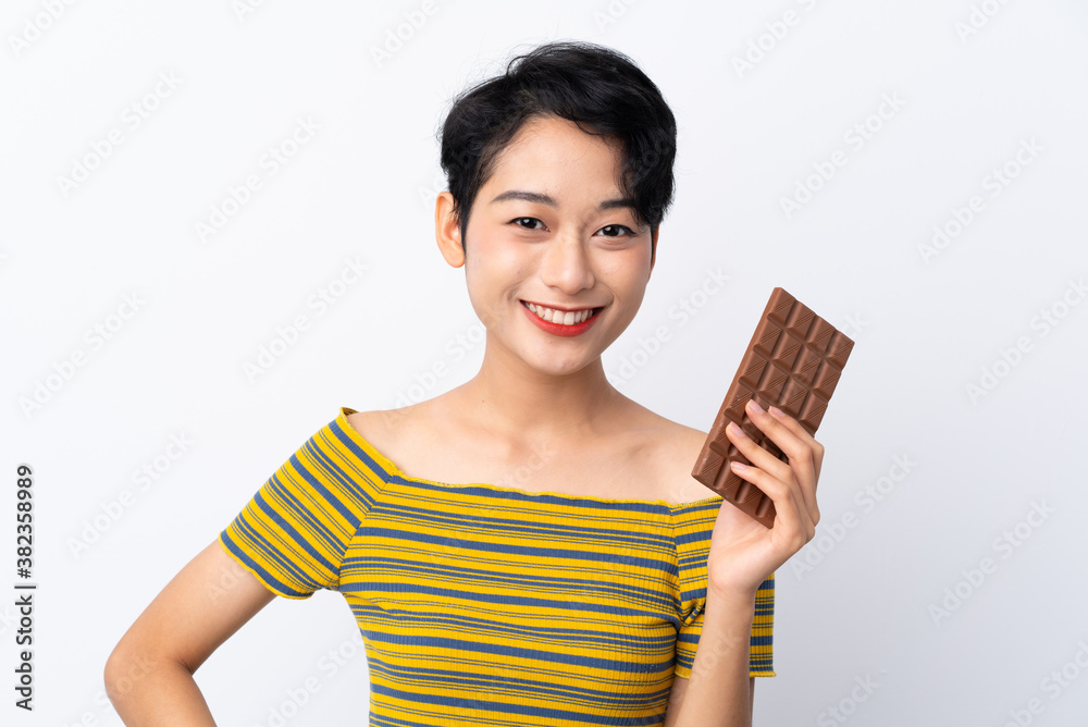 Young Asian girl taking a chocolate tablet and happy Young Asian girl taking a chocolate tablet and happy
