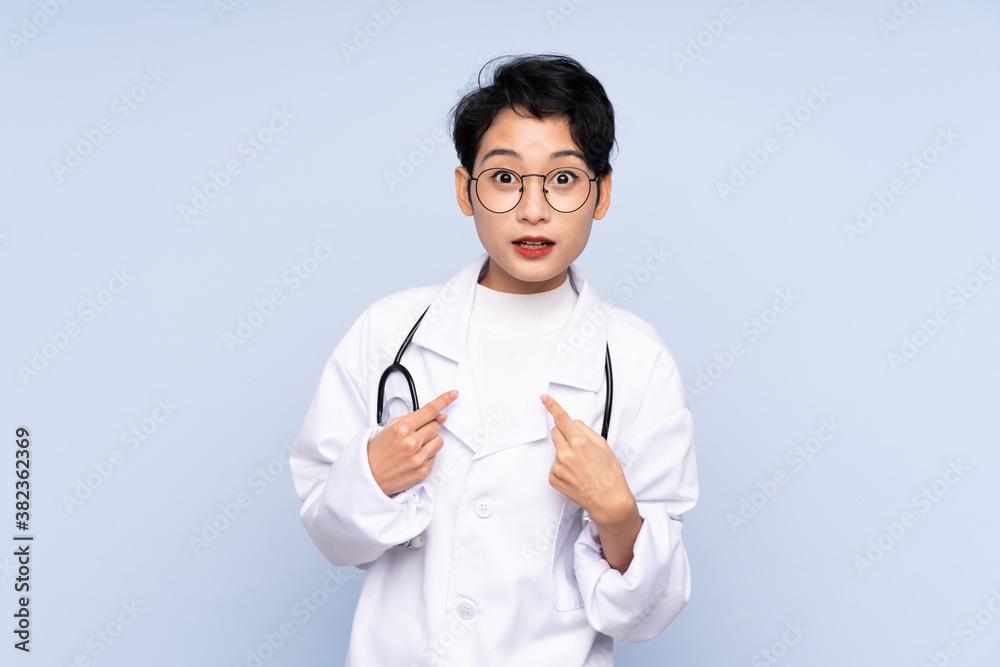 Doctor Asian woman over isolated blue background with surprise facial expression Doctor Asian woman over isolated blue background with surprise facial expression